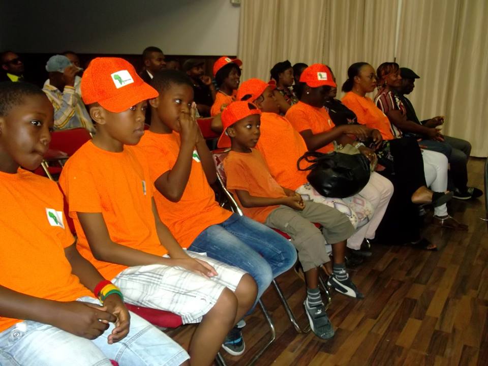 Solidarité et assistance humanitaire ACM — Enfants et adultes assis dans la salle pendant la rencontre.