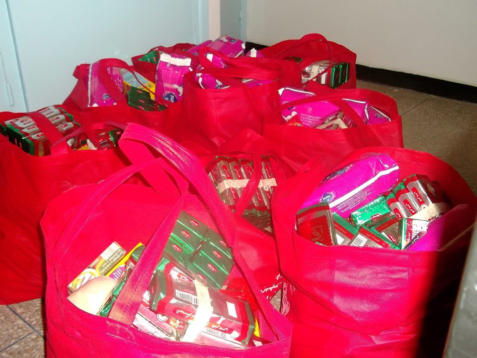 Distribution des kits ACM — Kits préparés dans des sacs rouges, avec leurs produits emballés.