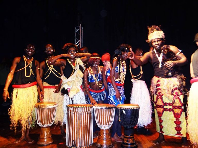 Journée internationale des migrants ACM — Les artistes réunis sur scène avec leurs instruments de percussion.