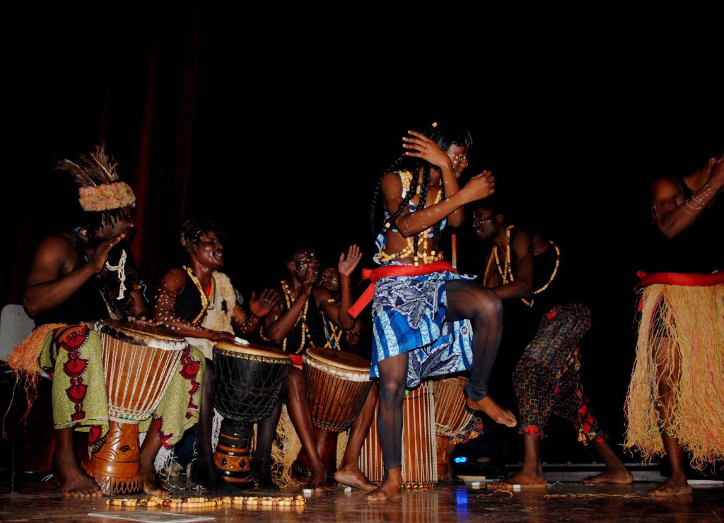 Journée internationale des migrants ACM — Une danseuse devant les instruments et les percussionnistes.