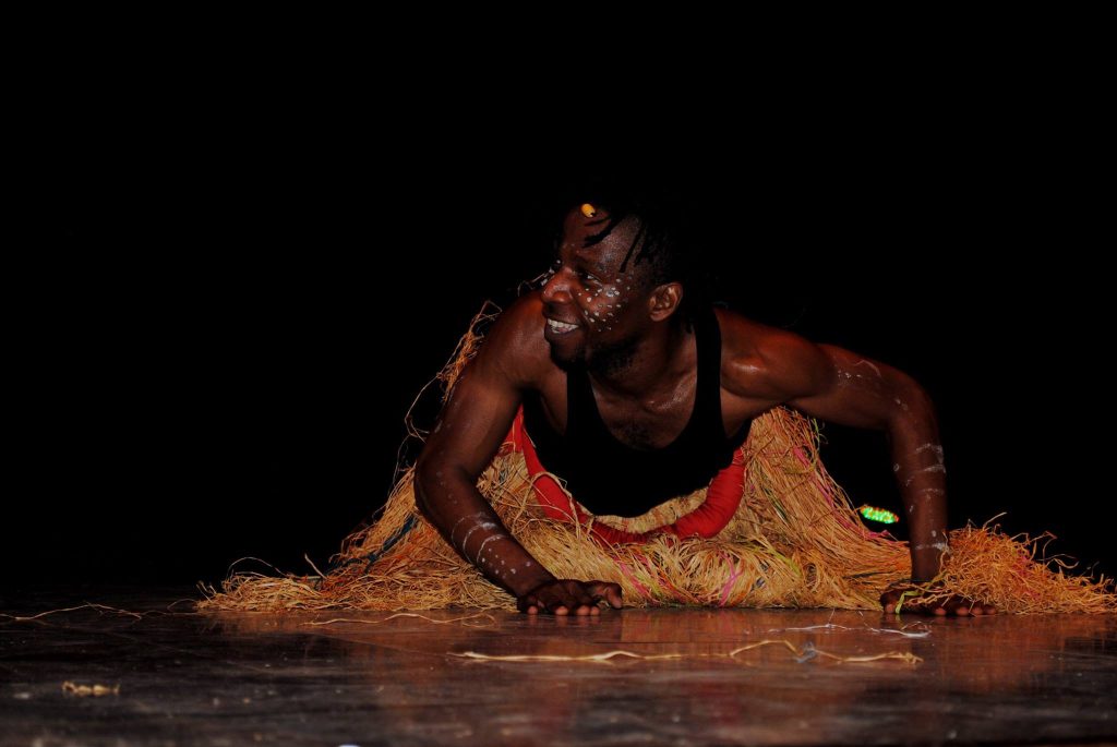 Journée internationale des migrants ACM — Un danseur réalise une figure au sol sur la scène.