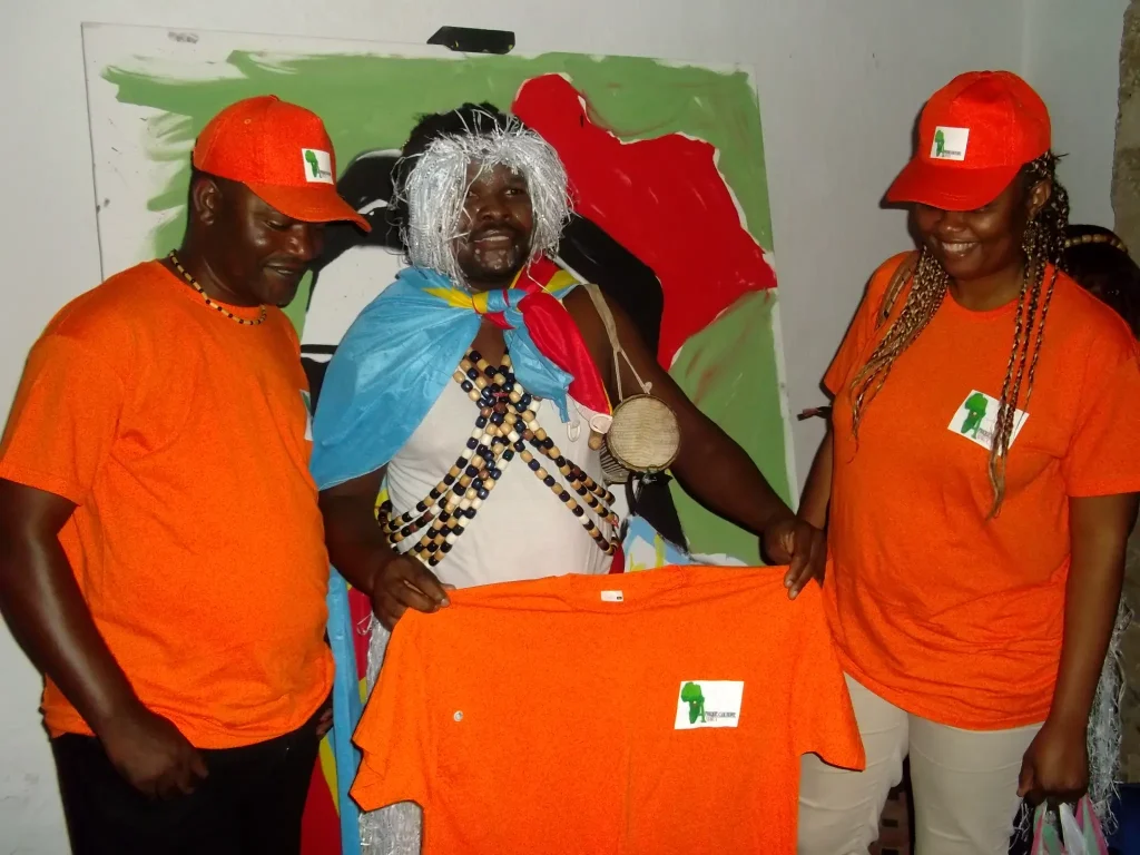 Solidarité et assistance humanitaire ACM — Présentation d’un tee-shirt orange portant le logo d’ACM.