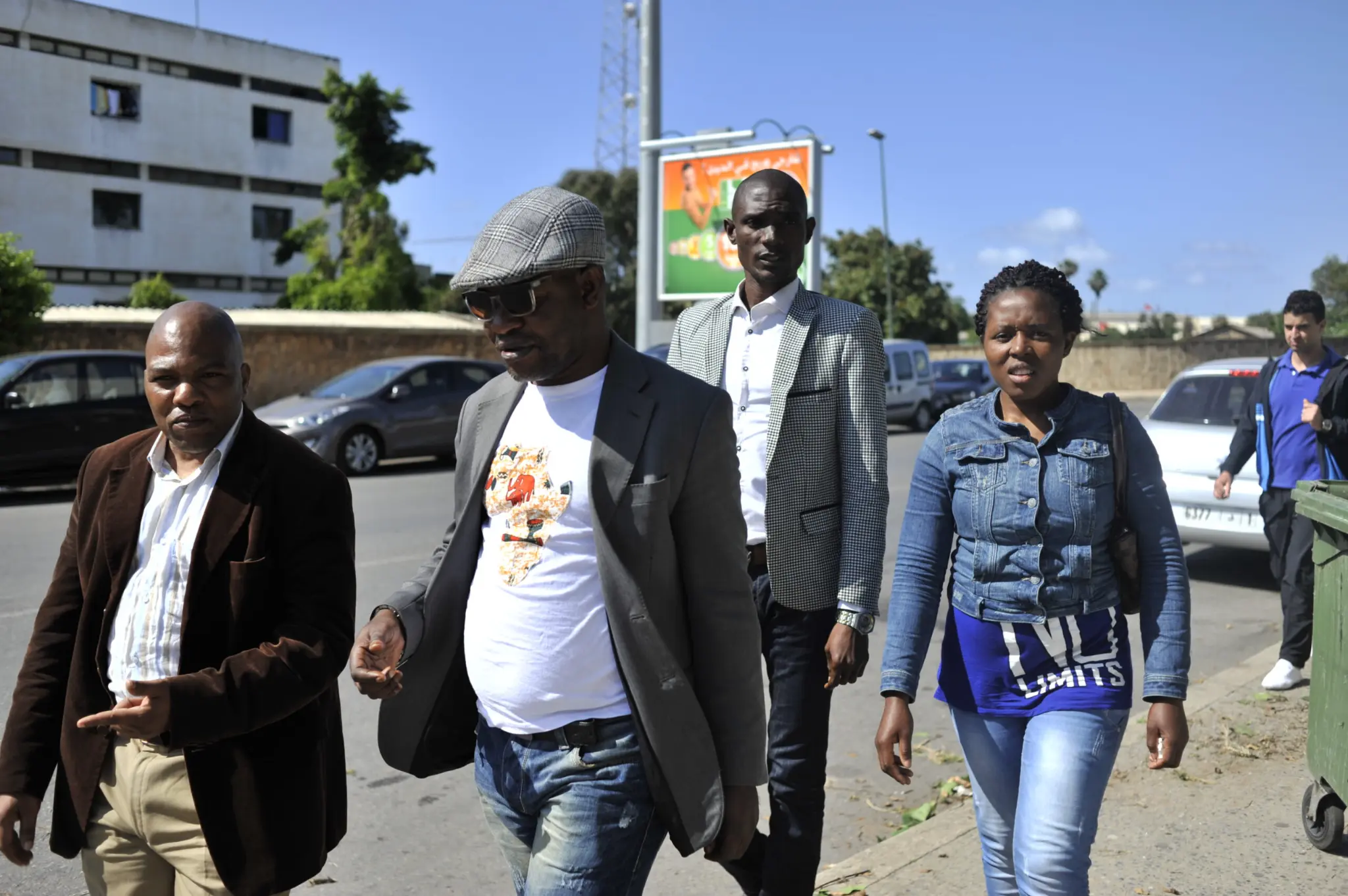 Un groupe de personnes marche dans une rue.